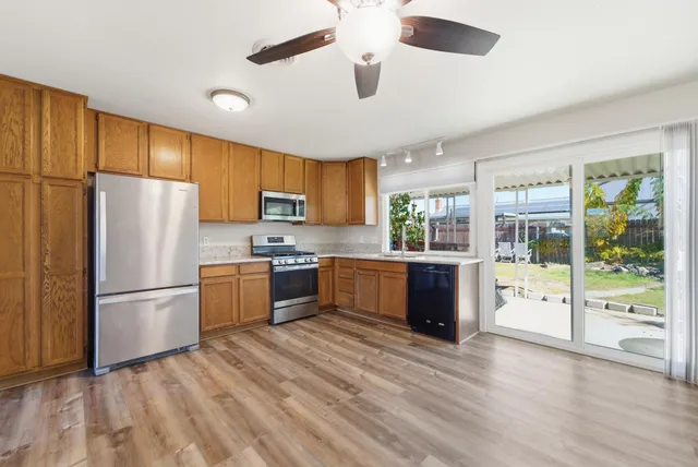 a kitchen with a refrigerator a stove top oven a refrigerator cabinets and wooden floor