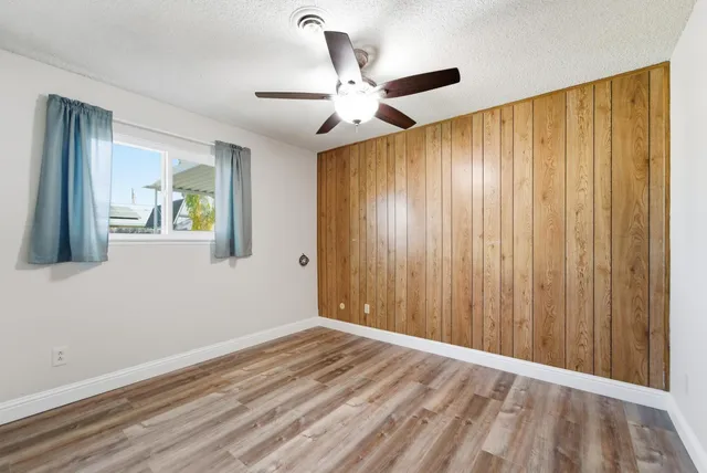 a view of a livingroom with wooden floor and a ceiling fan