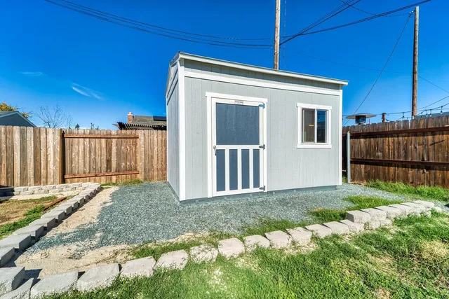 a view of a house with backyard and wooden fence