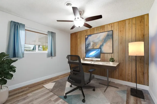 a view of a workspace with furniture and a window
