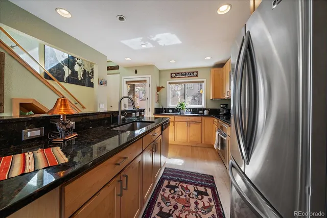 a kitchen with stainless steel appliances granite countertop a refrigerator and a sink