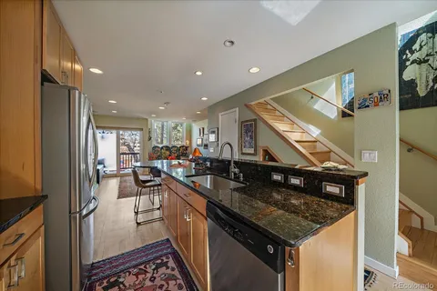 a kitchen with stainless steel appliances granite countertop a sink a stove and a refrigerator