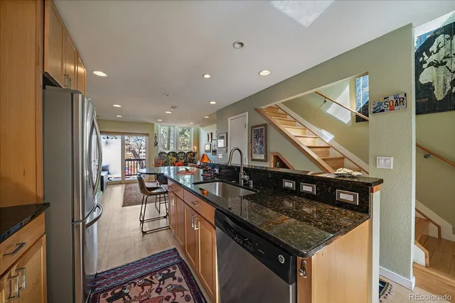 a kitchen with stainless steel appliances granite countertop a sink a stove and a refrigerator