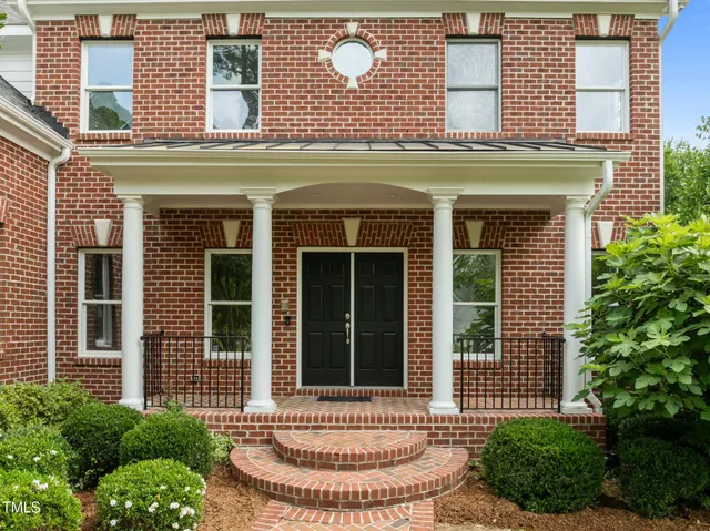 a dining room with furniture potted plants and wooden floor