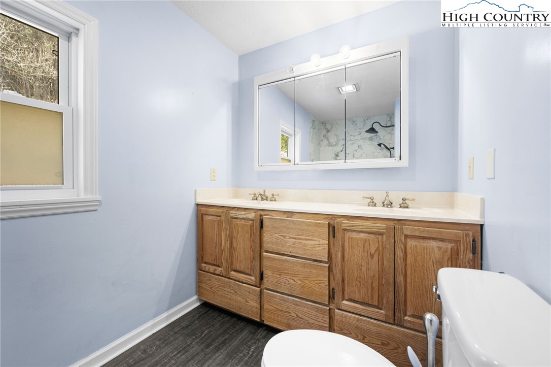 336 Willowdale Church Road Vilas, NC 28692 - Photo 16 of 45 a bathroom with a toilet a sink a mirror and a window