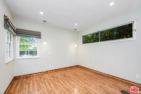 a view of empty room with wooden floor