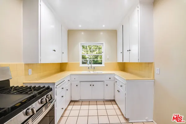 a kitchen with a sink a stove and cabinets