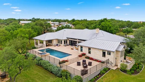 an aerial view of a house with swimming pool and a yard