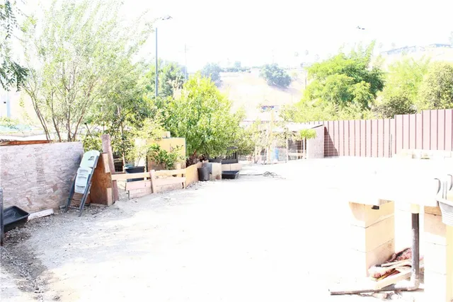 a view of backyard with a table and chairs and potted plants