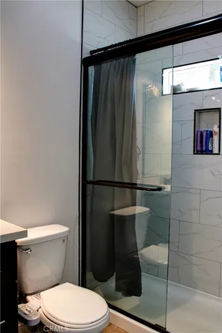 a bathroom with a toilet and a shower