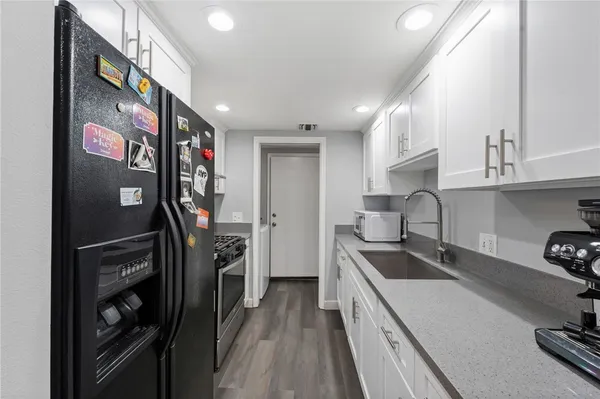 a kitchen that has a lot of cabinets a sink and appliances