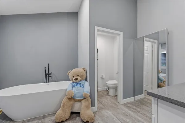 a bathroom with a sink and a washing machine with the mirror
