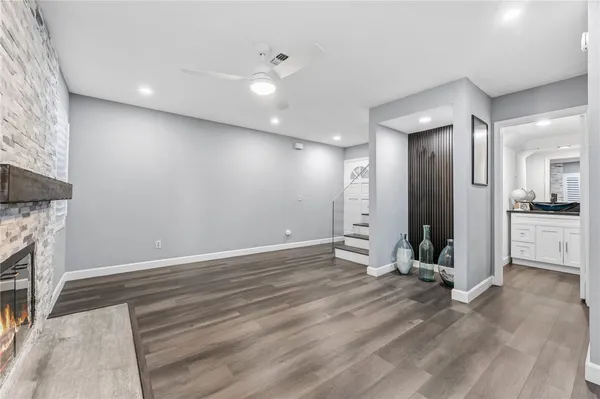 a view of a livingroom with wooden floor and a kitchen