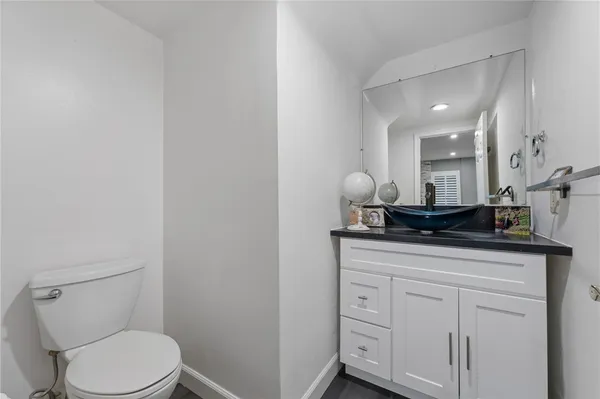 a bathroom with a toilet a sink and mirror