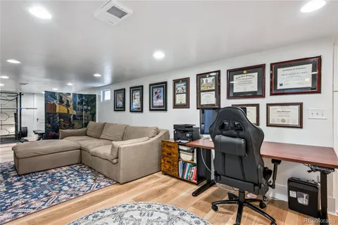 a roof deck with table and chairs under an umbrella with a fire pit