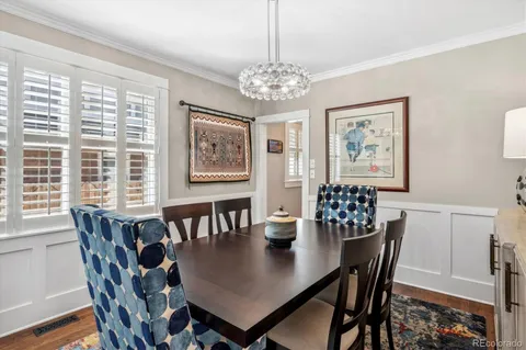 a kitchen with stainless steel appliances granite countertop a stove top oven a sink a dining table and chairs