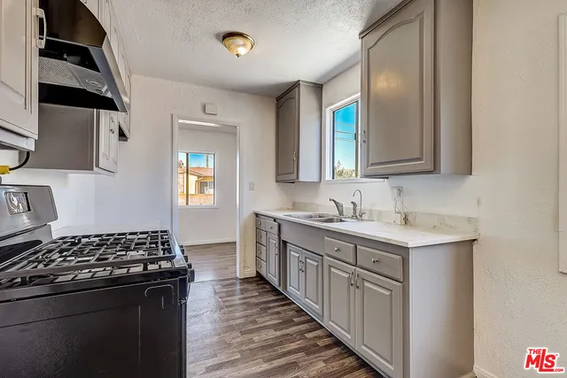 a kitchen with sink stove and cabinets