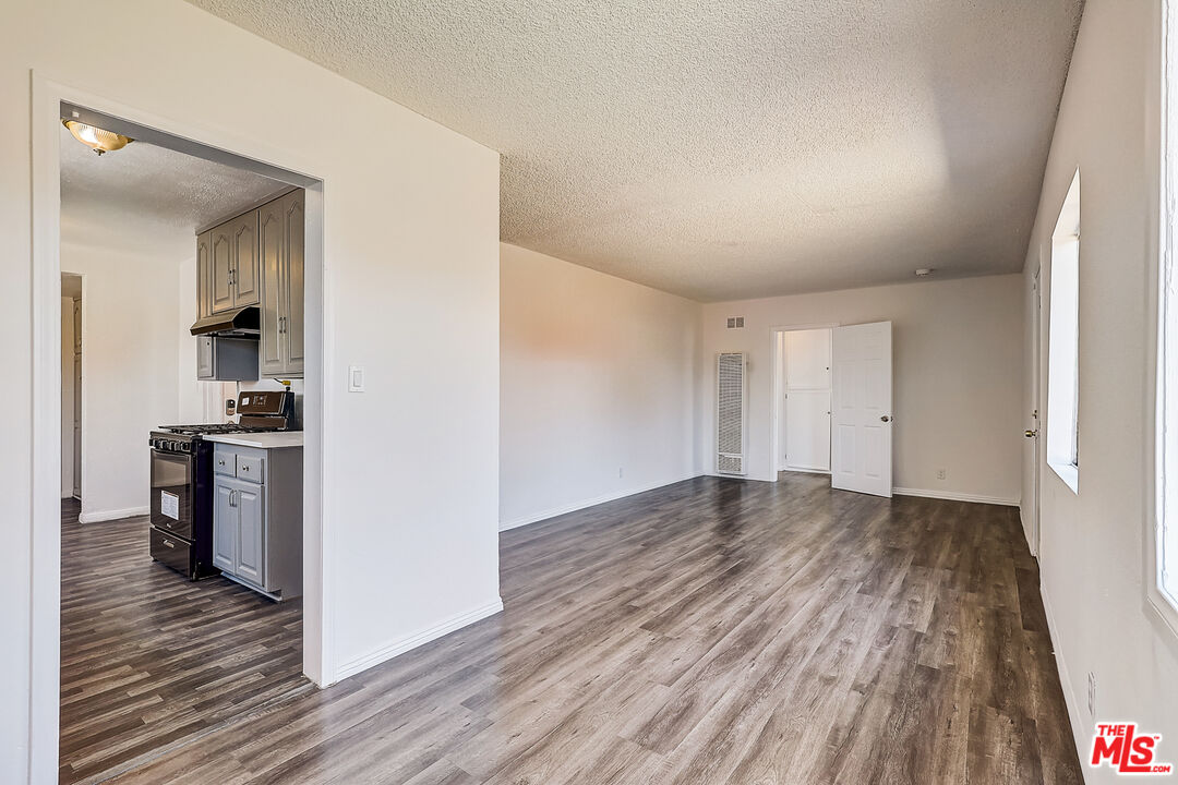 15815 South Haskins Avenue Compton, CA 90220 - Photo 15 of 29 a view of a room with wooden floor and a kitchen