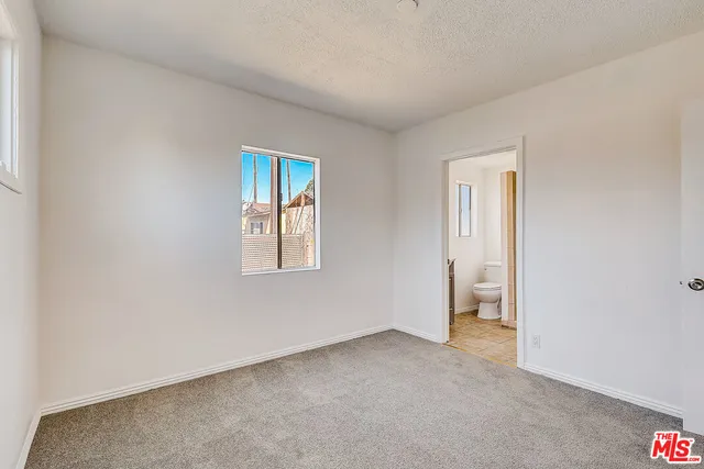 an empty room with a window and a bathroom