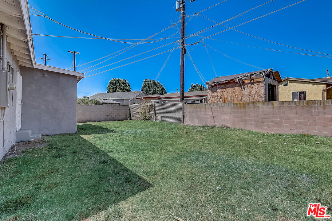 15815 South Haskins Avenue Compton, CA 90220 - Photo 25 of 29 a view of a backyard with table and chairs under an umbrella