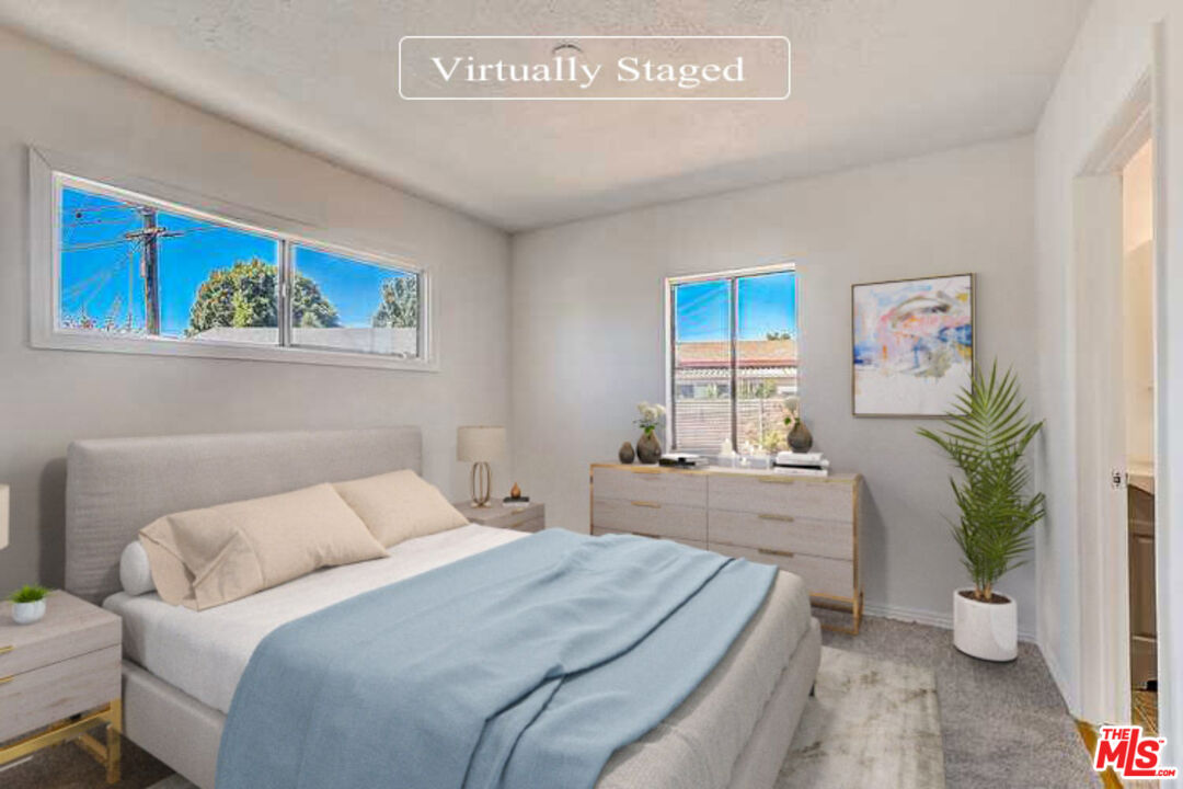 15815 South Haskins Avenue Compton, CA 90220 - Photo 3 of 29 a bedroom with a large bed a potted plant and a window