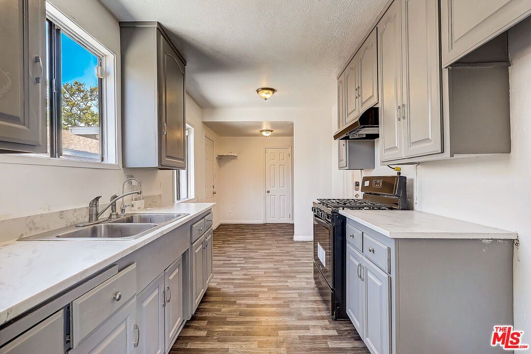 15815 South Haskins Avenue Compton, CA 90220 - Photo 4 of 29 a kitchen with a sink stove and cabinets