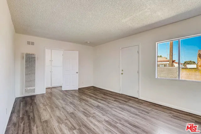a view of empty room with wooden floor and fireplace