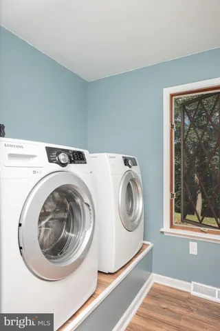 a view of a big room with wooden floor and windows