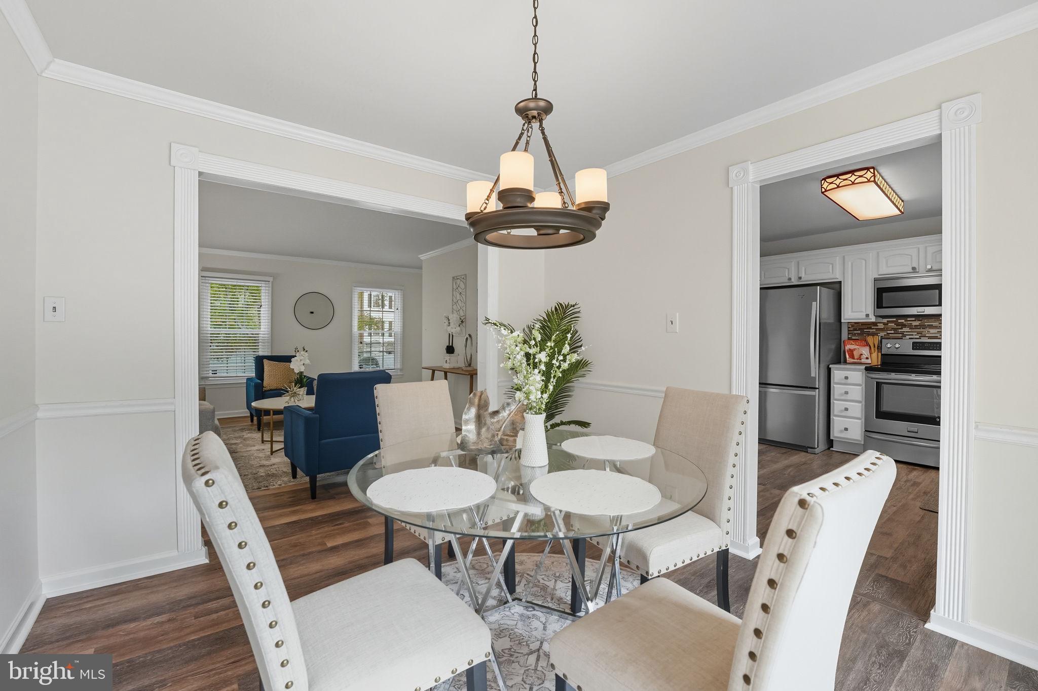 7954 Forest Path Way Springfield, VA 22153 - Photo 2 of 34 a dining room with furniture a chandelier and wooden floor