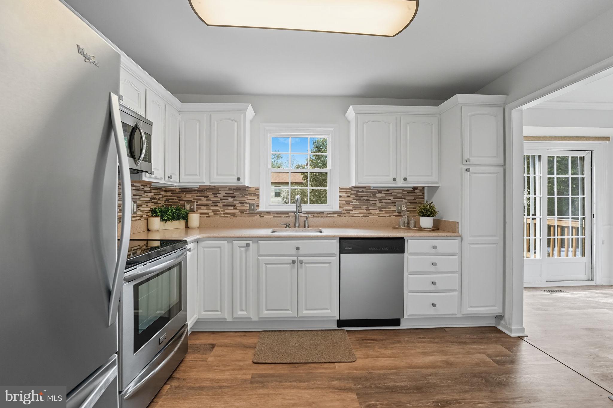 7954 Forest Path Way Springfield, VA 22153 - Photo 3 of 34 a kitchen with granite countertop white cabinets and white appliances