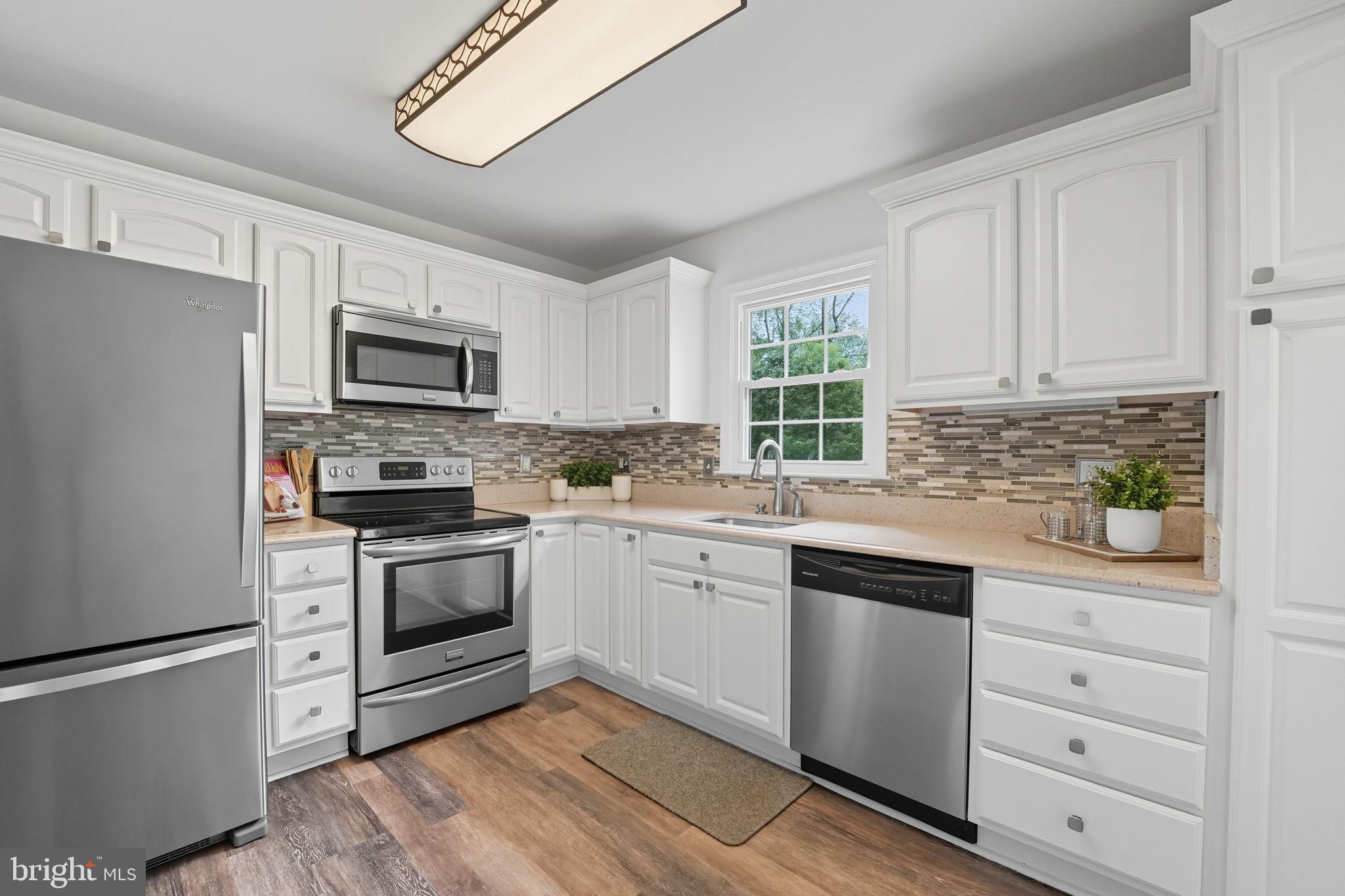 7954 Forest Path Way Springfield, VA 22153 - Photo 4 of 34 a kitchen with cabinets stainless steel appliances and window