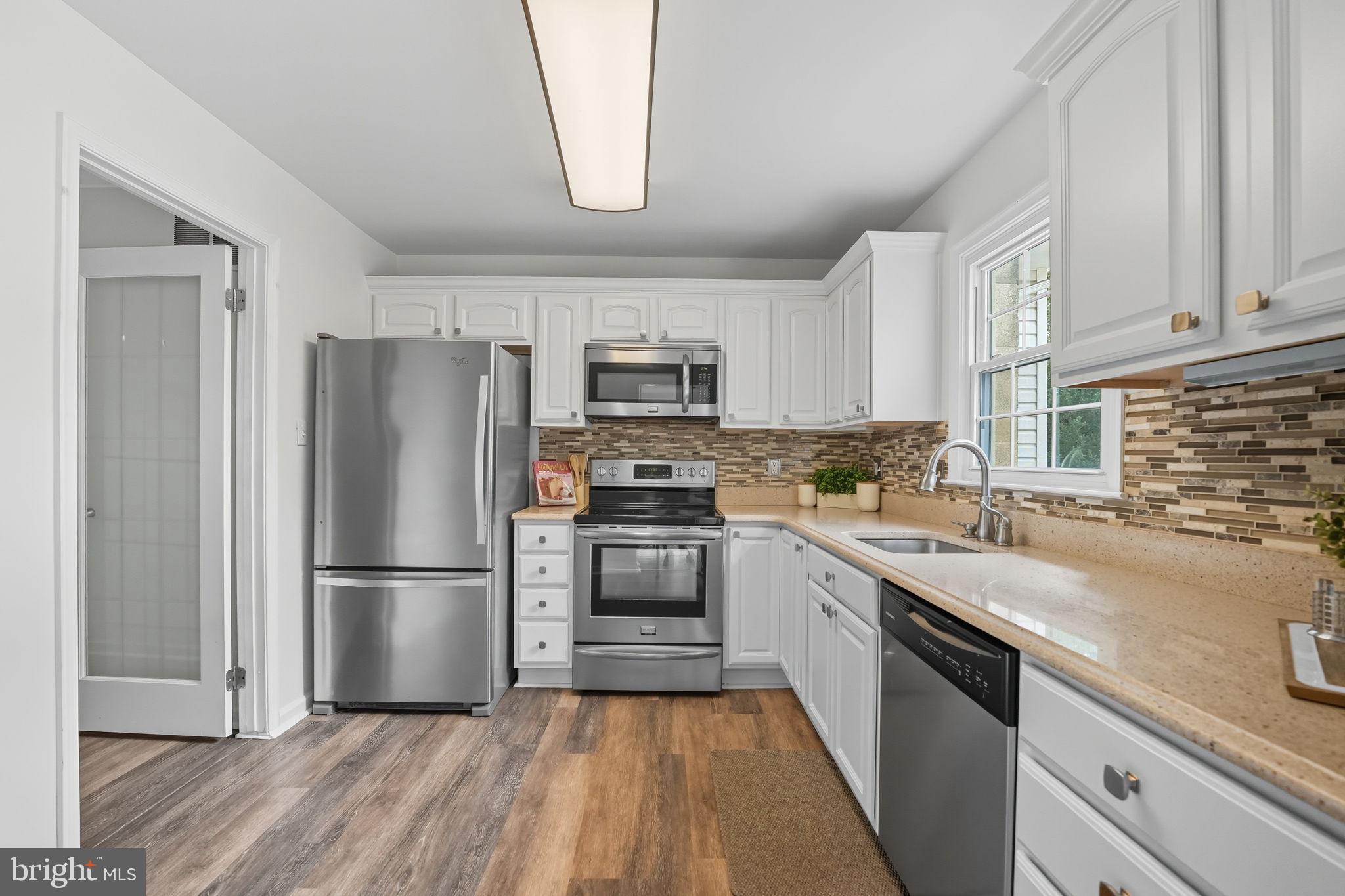 7954 Forest Path Way Springfield, VA 22153 - Photo 5 of 34 a kitchen with granite countertop a refrigerator oven a sink dishwasher and a stove with wooden floor