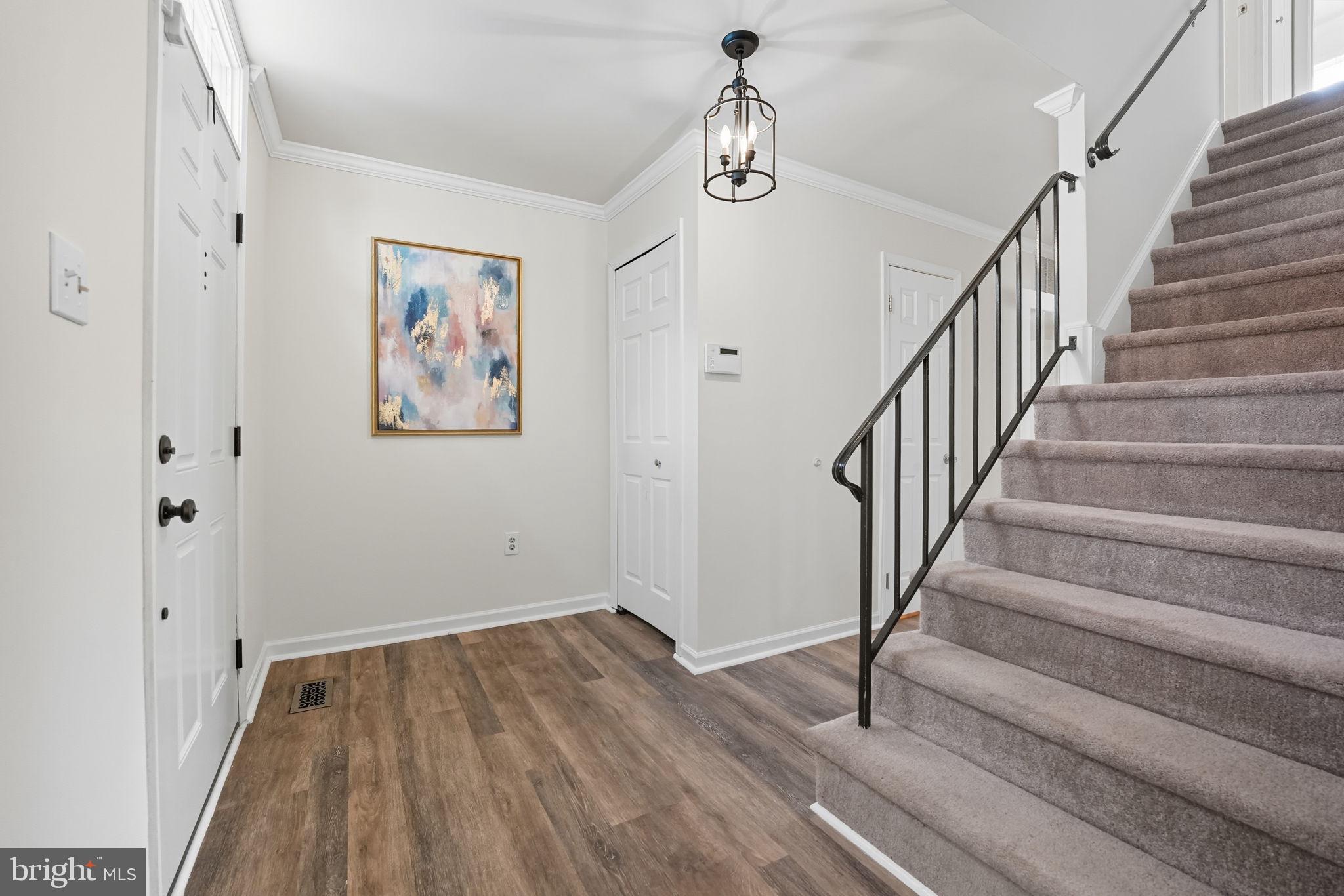7954 Forest Path Way Springfield, VA 22153 - Photo 10 of 34 a view of a hallway with wooden floor and stairs