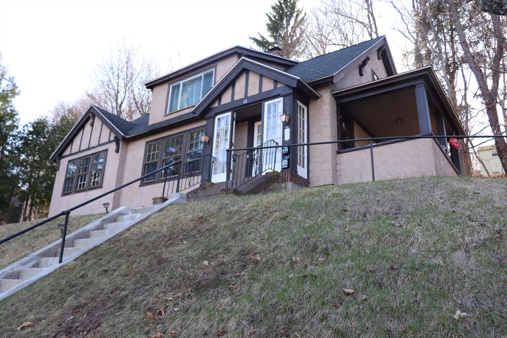 a view of a house with a yard and large tree