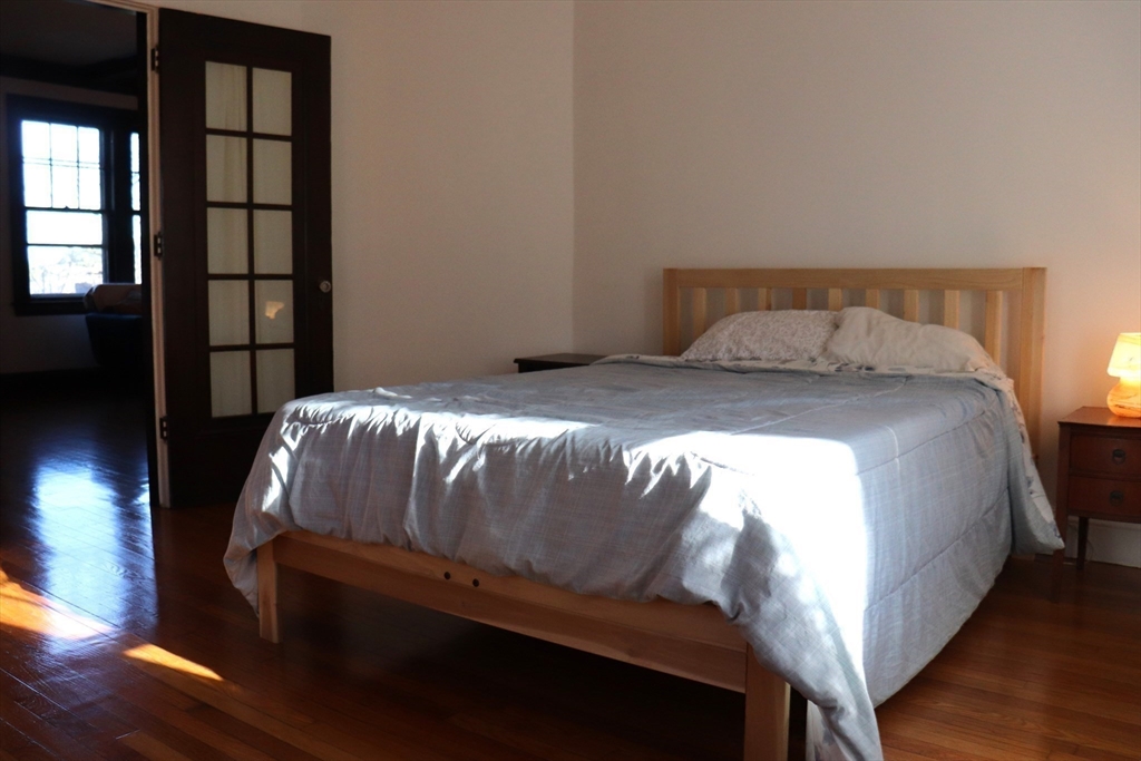 26 St Elmo Road Worcester, MA 01602 - Photo 14 of 42 a bedroom with a bed and wooden floor