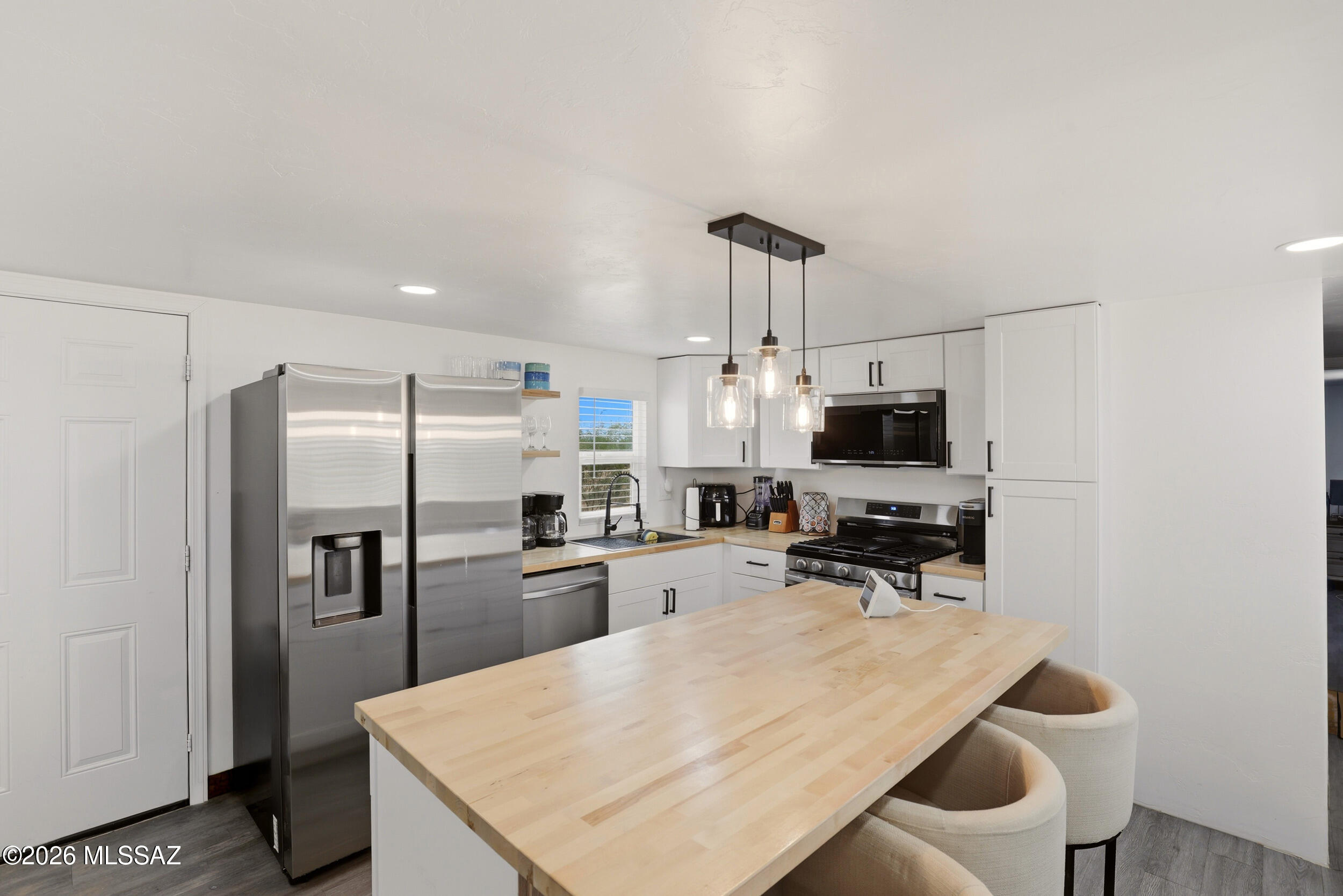 8620 South Sandario Road Tucson, AZ 85736 - Photo 11 of 26 a kitchen with refrigerator and chairs