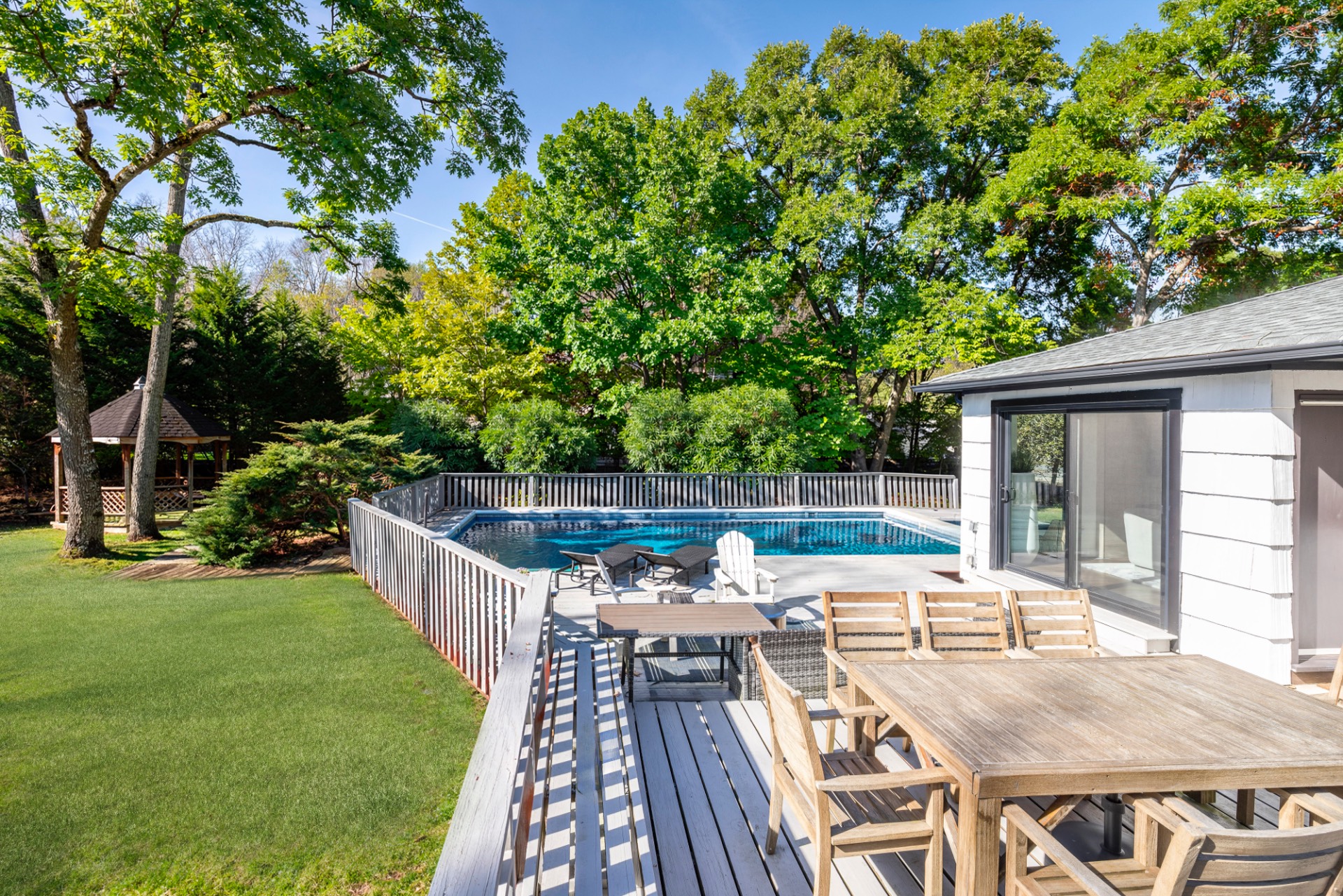 137 North Sea Mecox Road Southampton, NY 11968 - Photo 1 of 16 a view of a patio with table and chairs with wooden floor and fence