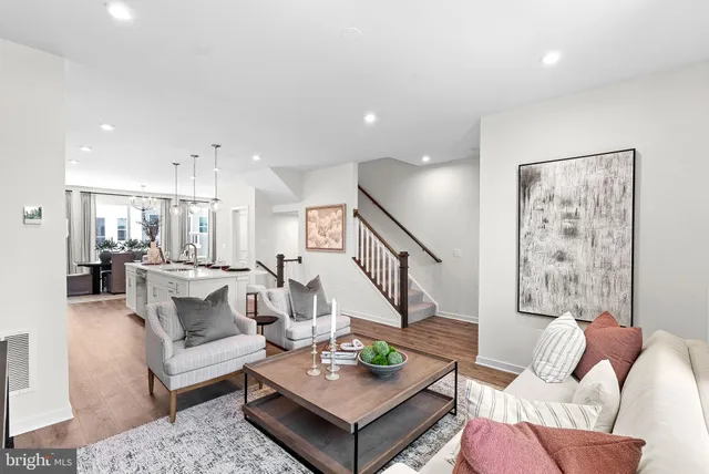 a living room with furniture and a view of kitchen