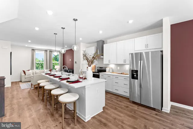 a kitchen with a dining table chairs stove refrigerator and living room view