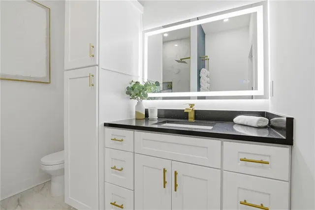 a bathroom with a granite countertop sink and a mirror