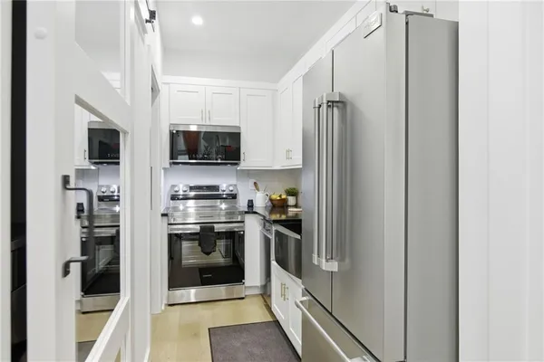a kitchen with stainless steel appliances granite countertop a refrigerator and a stove top oven