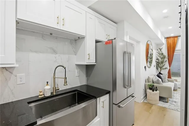 a kitchen with stainless steel appliances a sink a refrigerator and a counter space