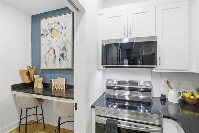 a kitchen with stainless steel appliances a stove a microwave and cabinets