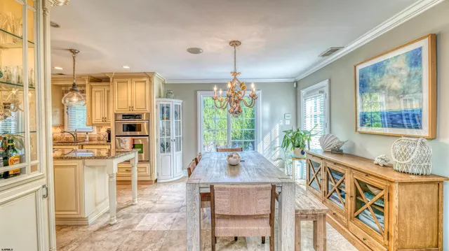 a kitchen with stainless steel appliances granite countertop a stove a sink dishwasher and a dining table with wooden floor