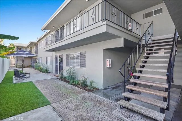 a view of an empty room with wooden floor and a ceiling fan