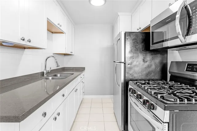 a kitchen with granite countertop a sink wooden floor and stainless steel appliances