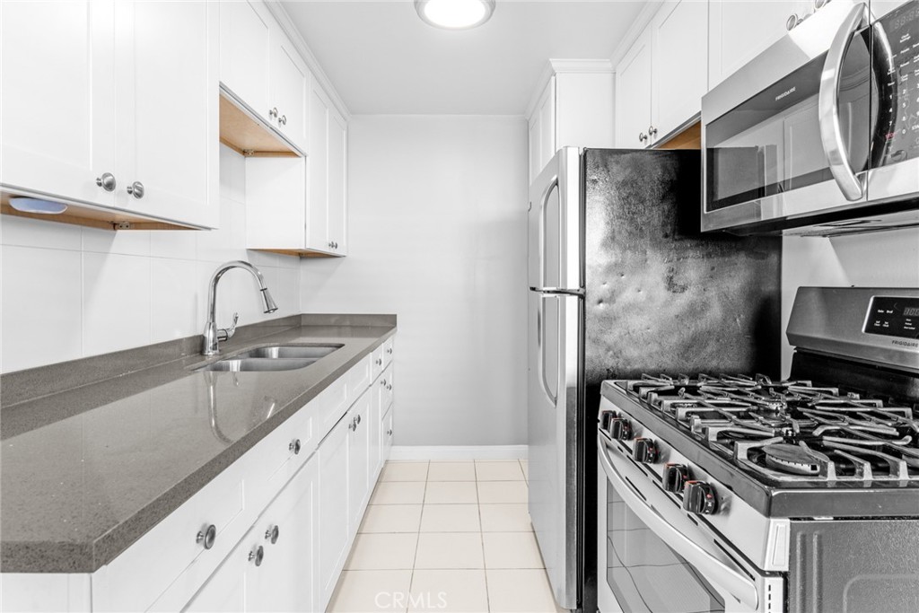 1106 Pacific Avenue Long Beach, CA 90813 - Photo 7 of 13 a kitchen with stainless steel appliances granite countertop a sink stove and refrigerator