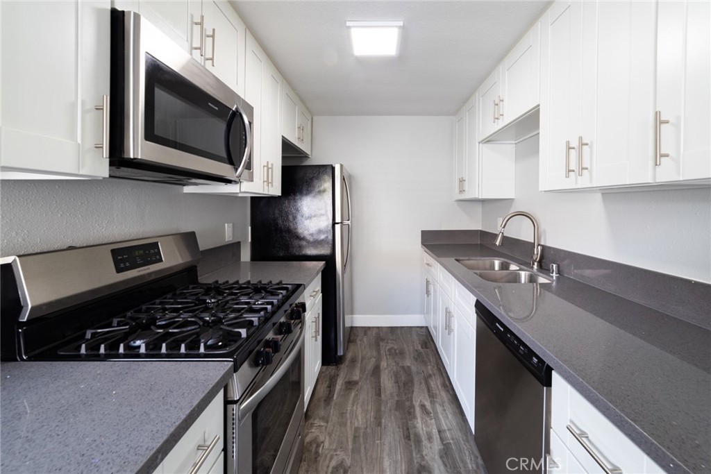 1106 Pacific Avenue Long Beach, CA 90813 - Photo 8 of 13 a kitchen with stainless steel appliances a sink dishwasher a stove and a microwave oven with cabinets