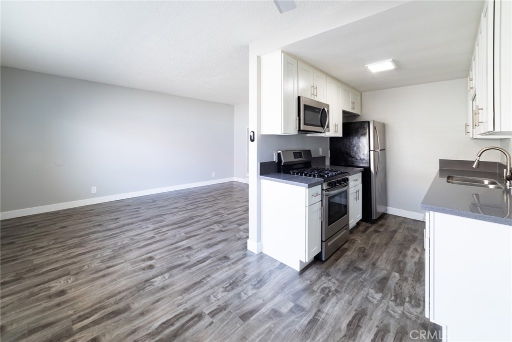 1106 Pacific Avenue Long Beach, CA 90813 - Photo 9 of 13 a kitchen with granite countertop a sink wooden floor and stainless steel appliances