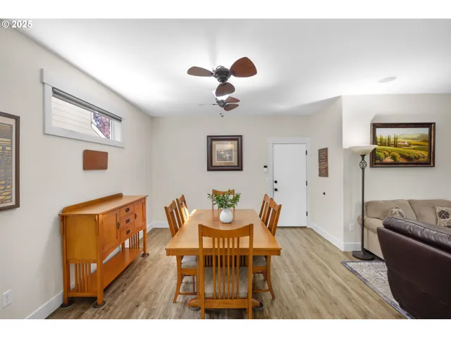 a living room with furniture wooden floor and wall paintings